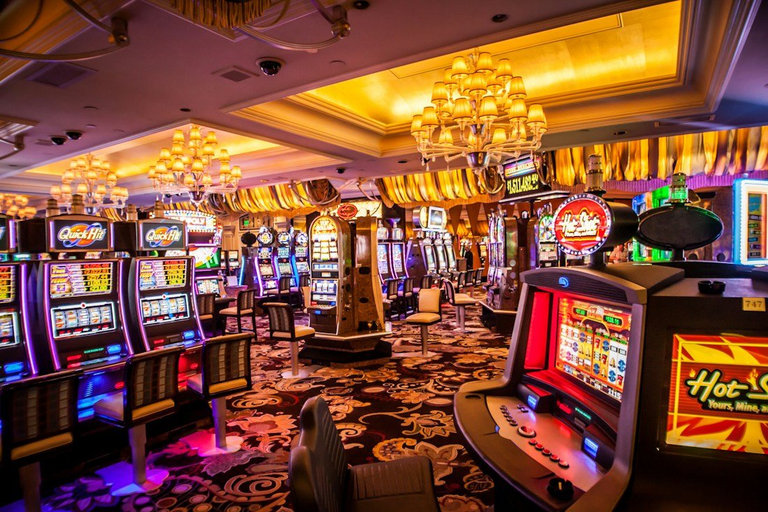 Bright casino floor with rows of slot machines